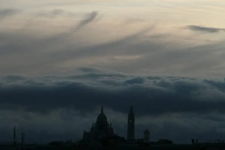 Foto eines stark bedeckten Wolkenhimmels über dem Vatikan. Erfahren Sie in diesem Blog-Artikel mehr über Machtmissbrauch in der Kirche und wie Sie damit umgehen können.
