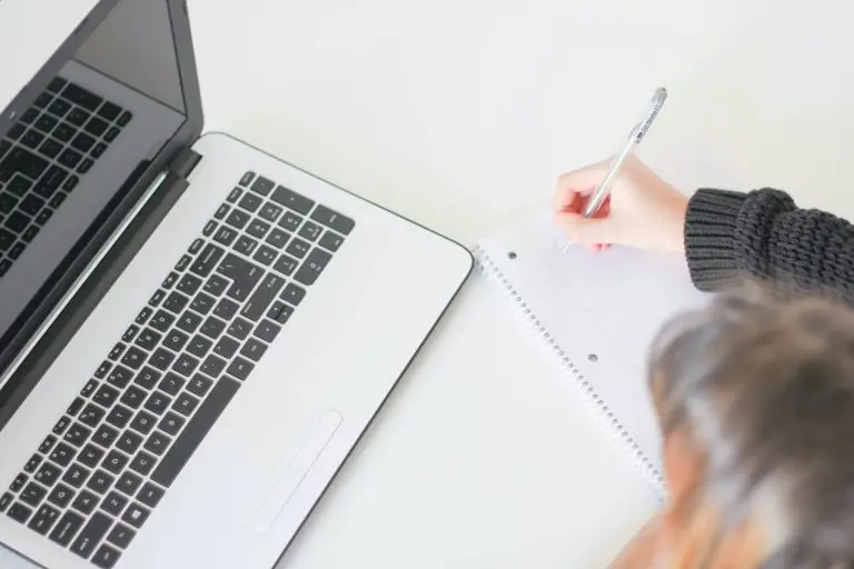Vogelperspektive einer Person, welche vor einem Laptop sitzt und sich Notizen macht. Erfahren Sie, wie sie die passende psychologische Fachperson finden